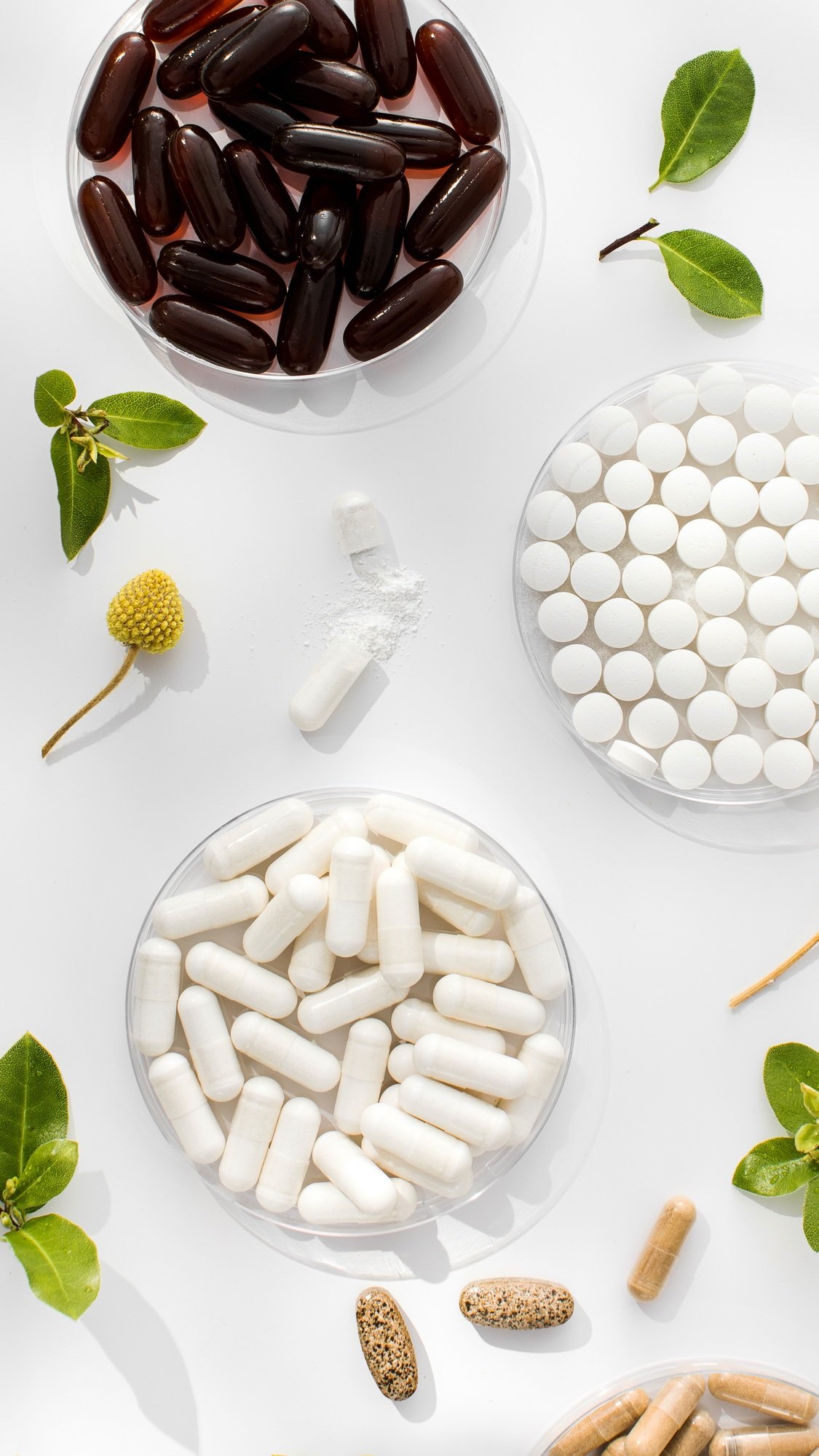 Various vitamins, tablets and dietary supplements with natural formulations on a white background.